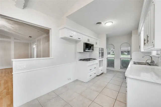 a kitchen with granite countertop a sink and cabinets