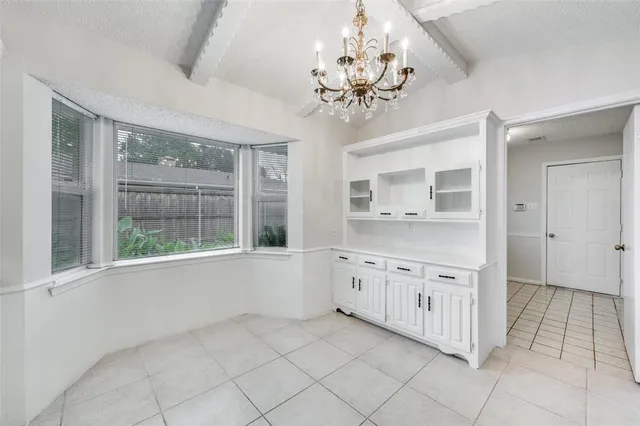 a large en suite bathroom with a granite countertop double vanity sink a mirror and a bathtub