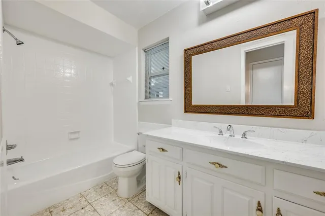 a bathroom with a toilet a sink a tub and a mirror