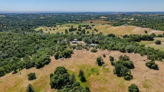 a view of an empty room with windows and chandelier fan