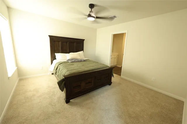 a spacious bedroom with a bed and a ceiling fan