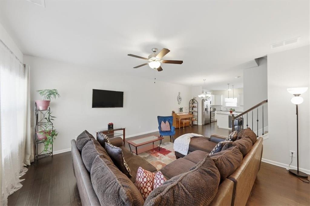 4154 Integrity Way Powder Springs, GA 30127 - Photo 25 of 52 a living room with furniture a ceiling fan and a rug