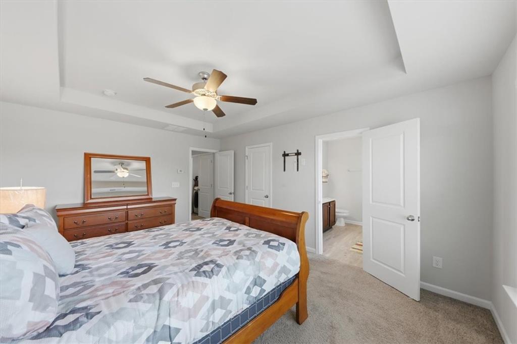 4154 Integrity Way Powder Springs, GA 30127 - Photo 29 of 52 a bedroom with a large bed and a chandelier