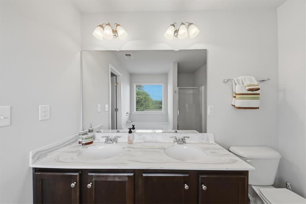 4154 Integrity Way Powder Springs, GA 30127 - Photo 31 of 52 a bathroom with a toilet a sink and mirror