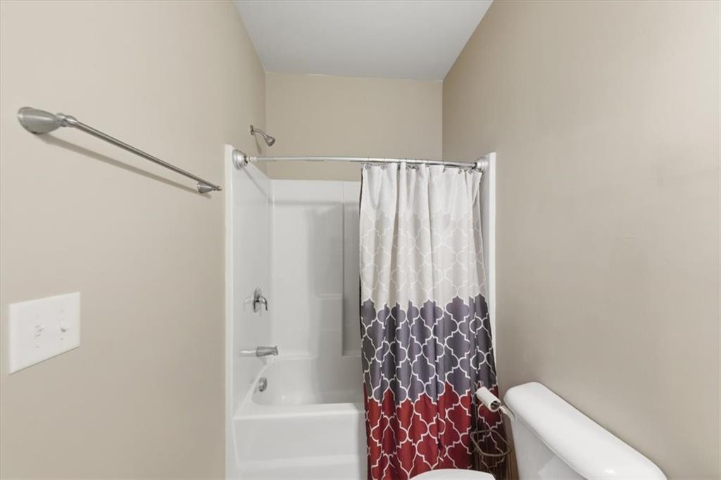4154 Integrity Way Powder Springs, GA 30127 - Photo 9 of 52 a bathroom with a shower curtain and a toilet