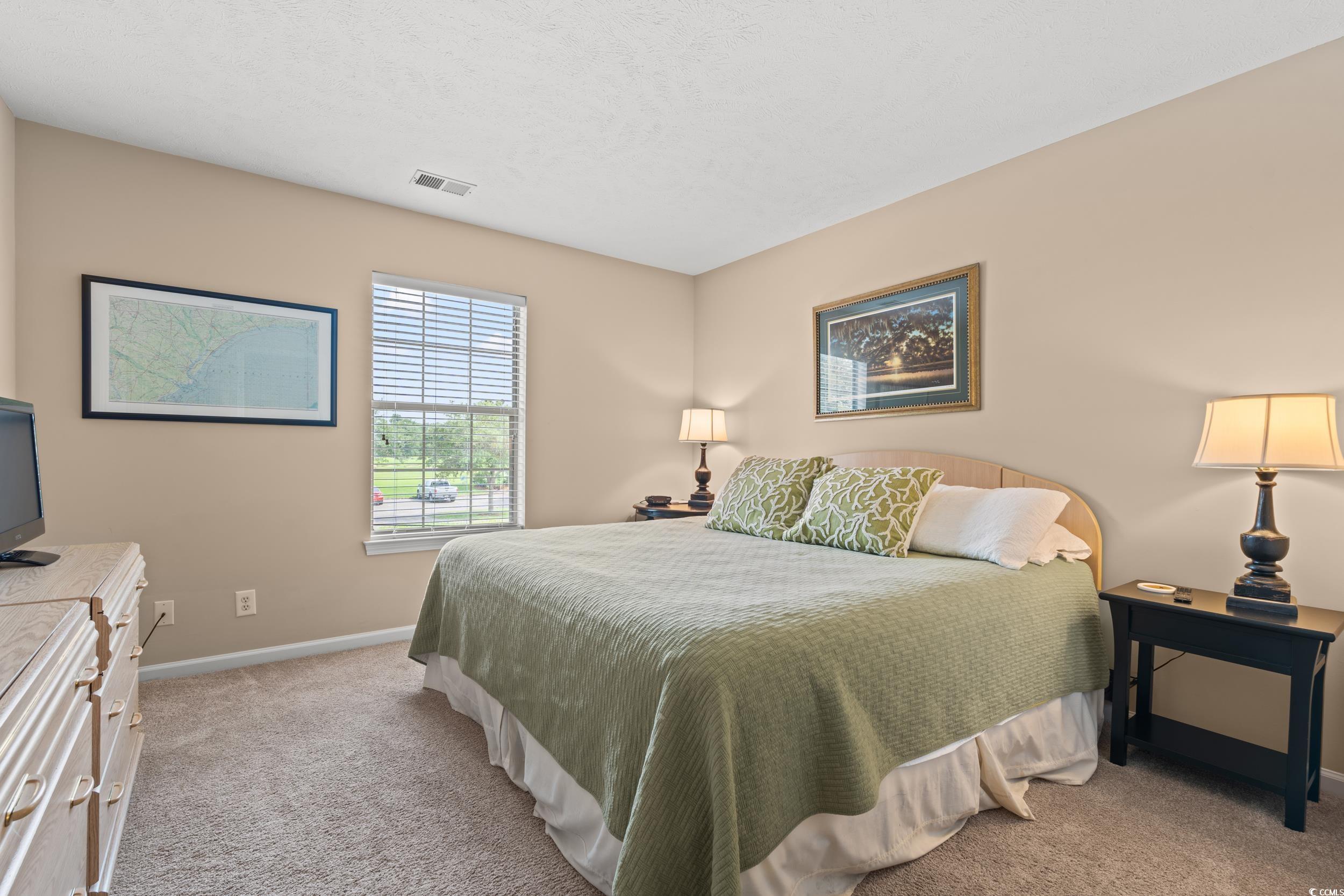 117 Pinehurst Lane, Unit 5E Pawleys Island, SC 29585 - Photo 12 of 40 Bedroom with light colored carpet and a textured ceiling