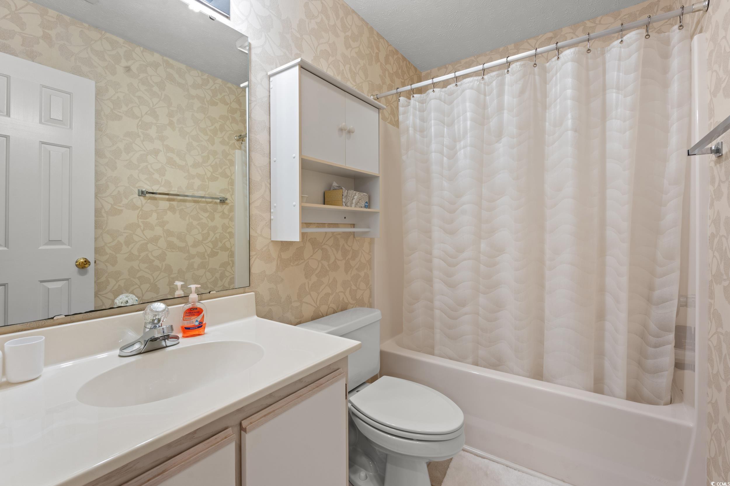 117 Pinehurst Lane, Unit 5E Pawleys Island, SC 29585 - Photo 14 of 40 Full bath featuring wallpapered walls, shower / bath combo with shower curtain, and vanity