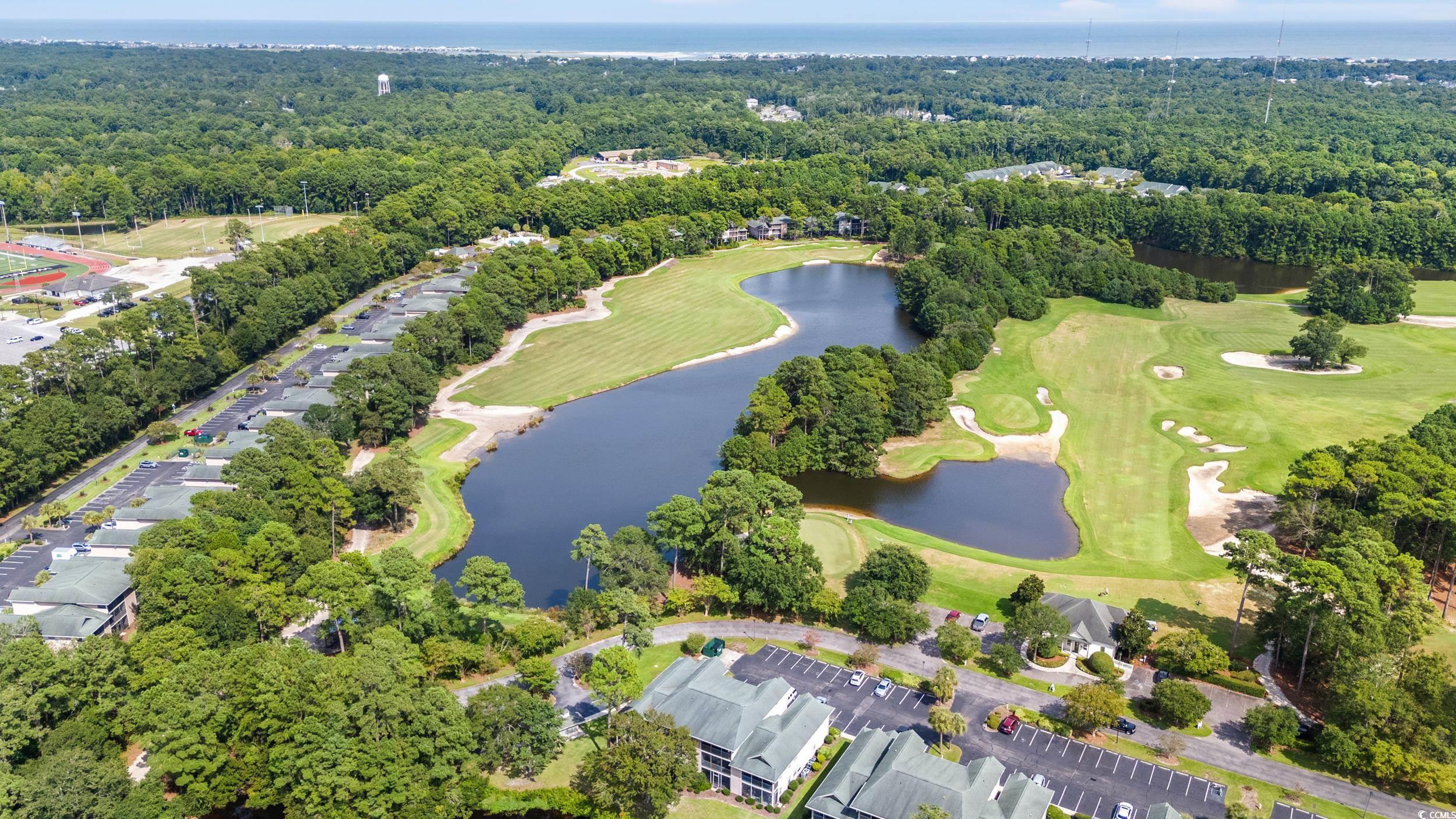 117 Pinehurst Lane, Unit 5E Pawleys Island, SC 29585 - Photo 17 of 40 Aerial view of property and surrounding area with a nearby body of water and a heavily wooded area