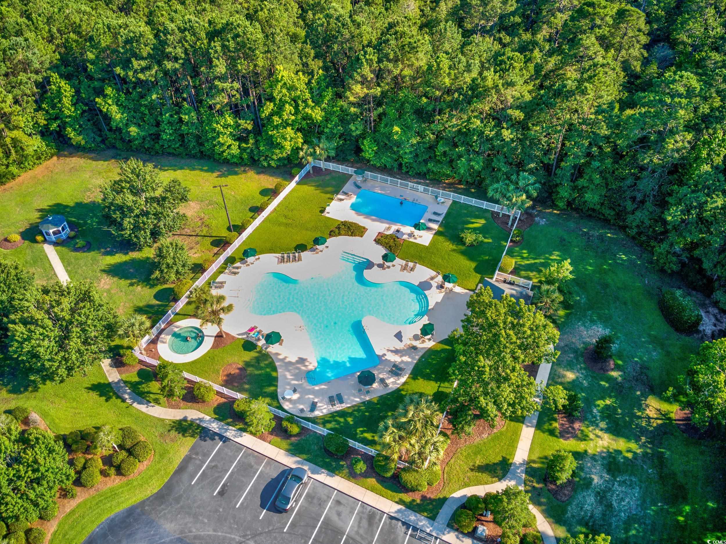 117 Pinehurst Lane, Unit 5E Pawleys Island, SC 29585 - Photo 21 of 40 Drone / aerial view of a pool and a forest