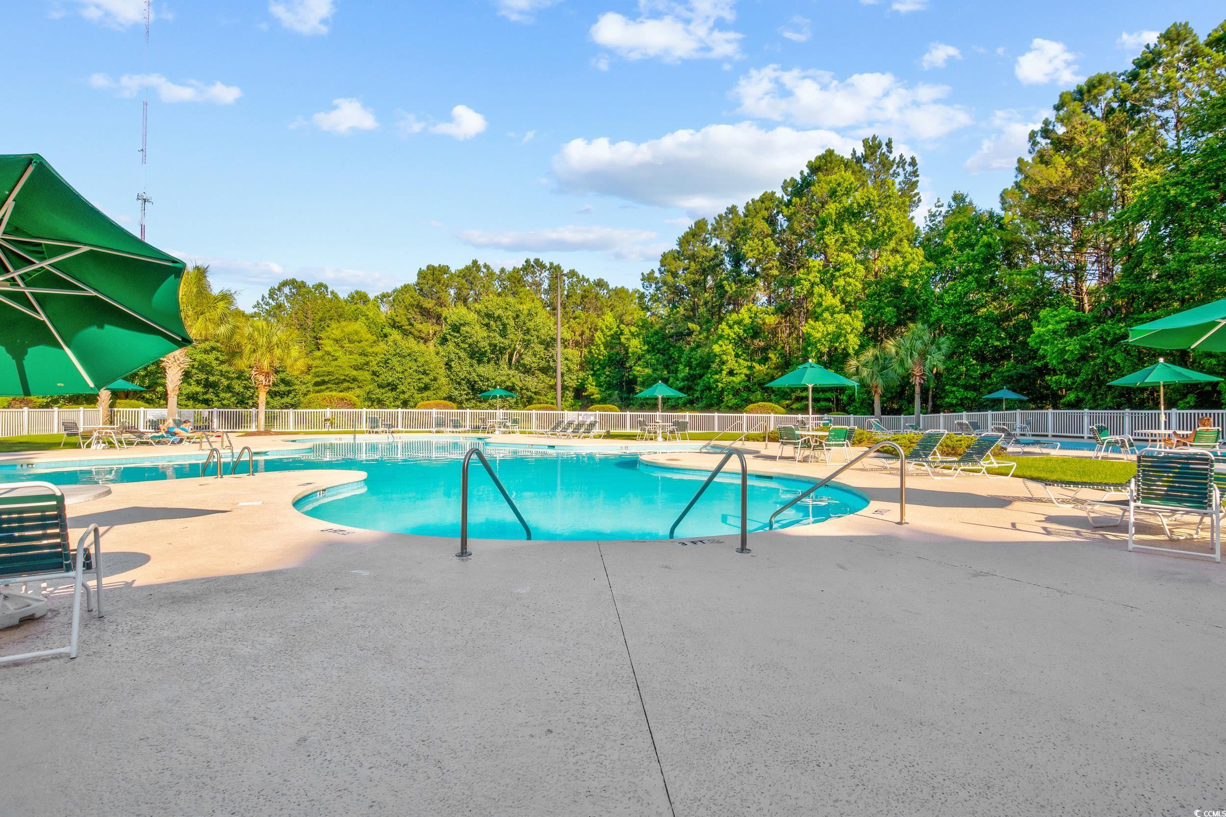 117 Pinehurst Lane, Unit 5E Pawleys Island, SC 29585 - Photo 24 of 40 Community pool featuring view of wooded area and a patio area