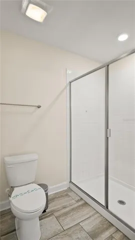 a white toilet sitting next to a shower