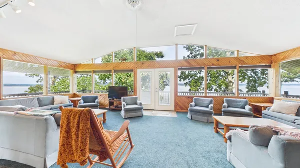 a living room with furniture a rug and kitchen view