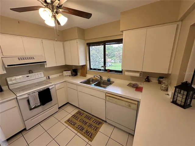 a kitchen that has a sink cabinets and window