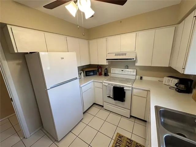 a kitchen with a refrigerator sink and cabinets