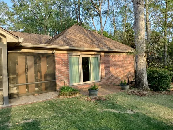 a backyard of a house with lawn chairs and plants