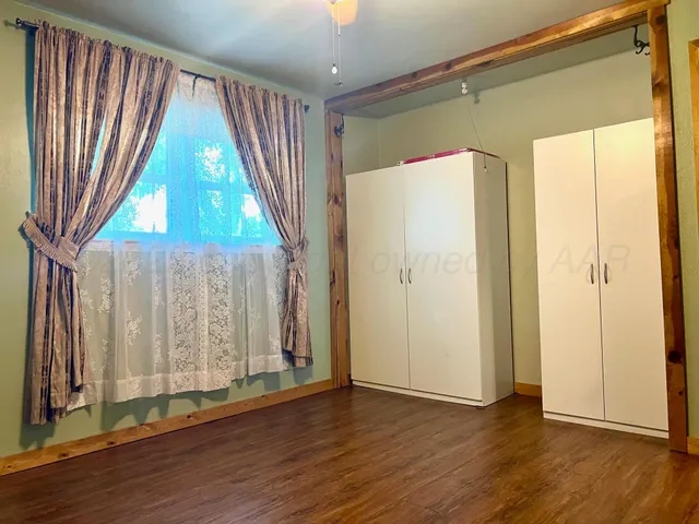 a view of a room with wooden floor and door