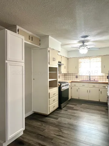 a view of a kitchen with refrigerator stove and wooden floor