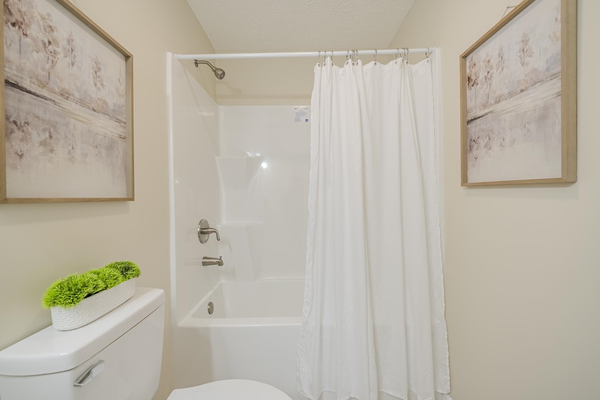 231 Clausel Lane Adamsville, TN 38310 - Photo 20 of 32 a bathroom with a toilet and a shower curtain