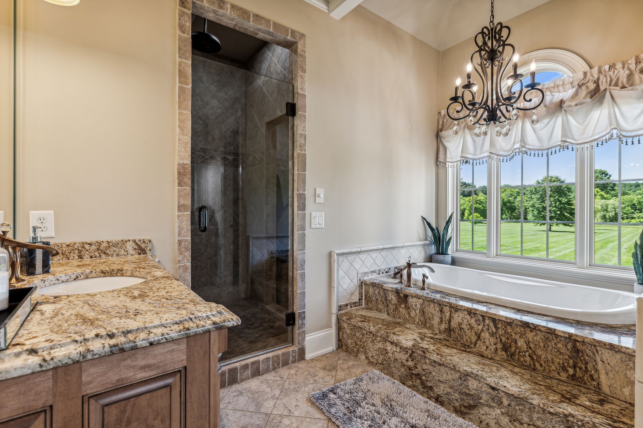 6035 River Trace Nashville, TN 37218 - Photo 32 of 68 a bathroom with a granite countertop sink a large mirror and a bathtub with shower