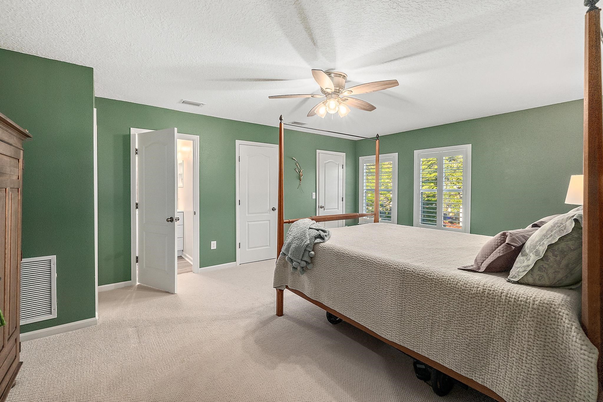 915 Saltwater Circle St. Augustine, FL 32080 - Photo 31 of 60 a bedroom with a large bed and a chandelier