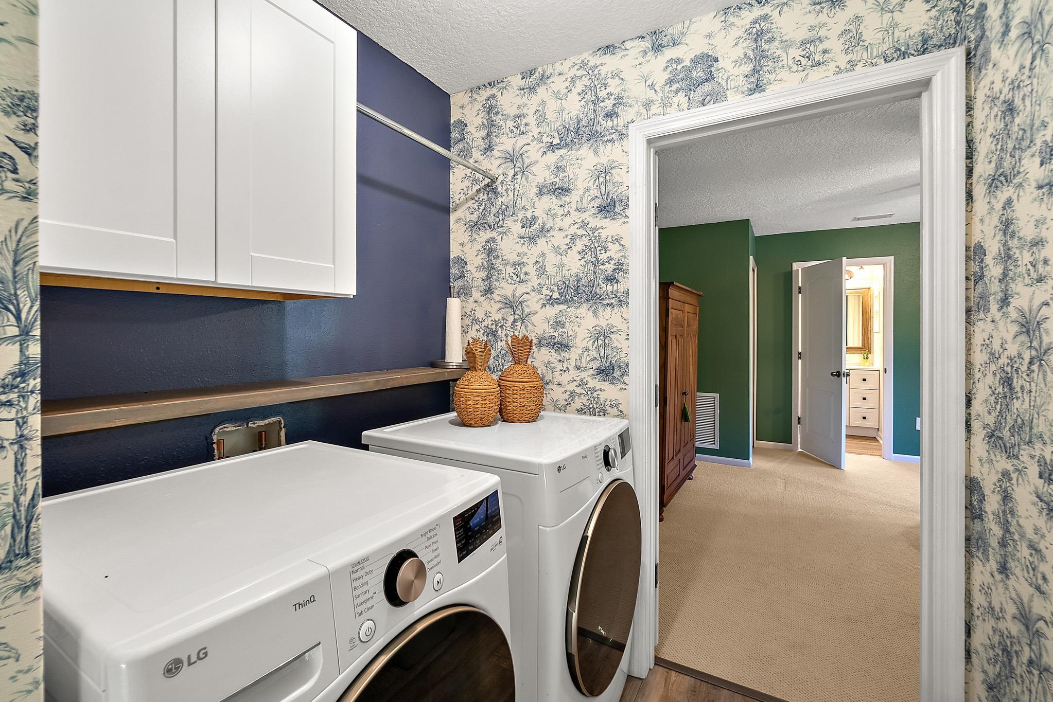 915 Saltwater Circle St. Augustine, FL 32080 - Photo 33 of 60 Laundry area featuring a textured ceiling, wallpapered walls, carpet, washer and dryer, and cabinet space