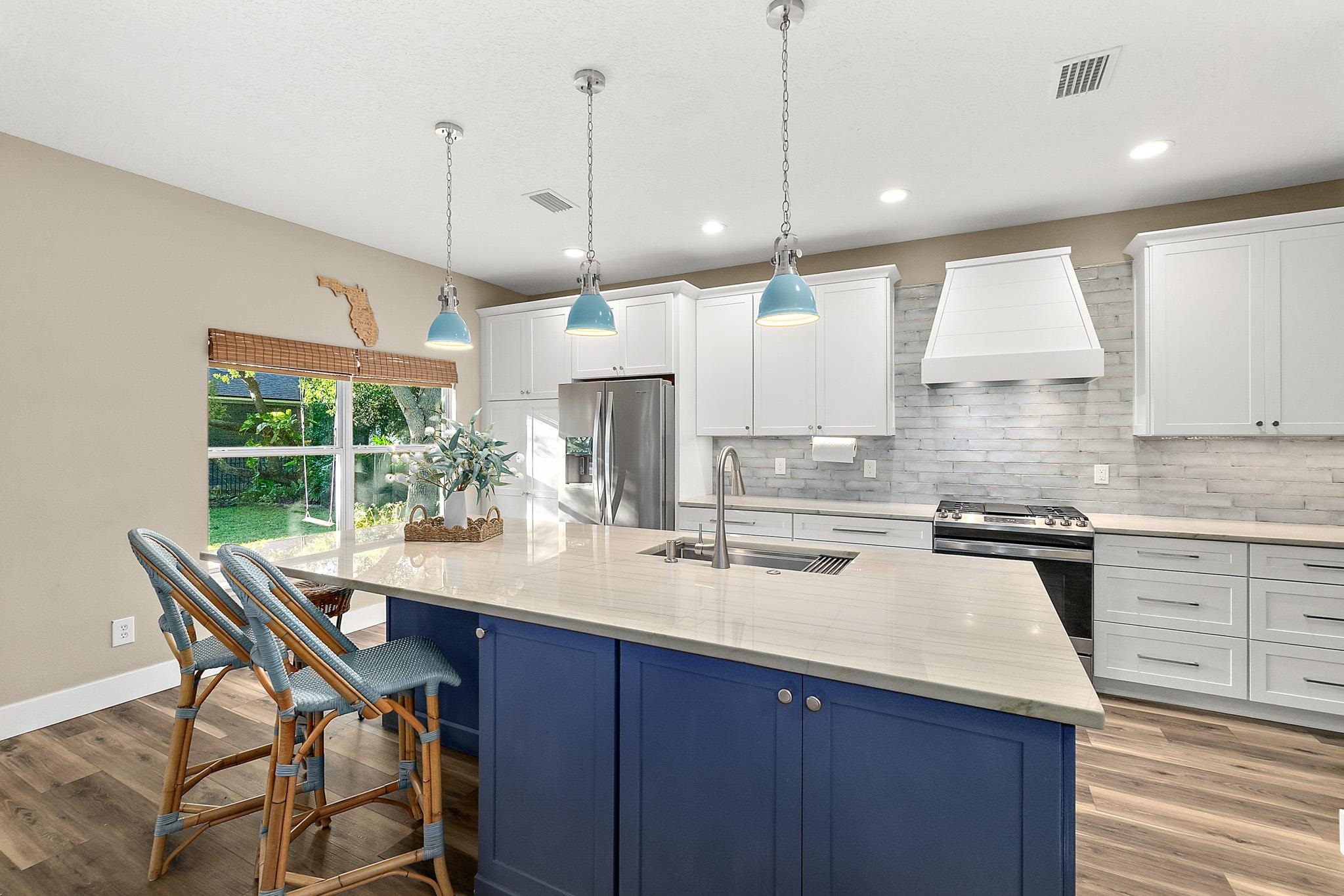 915 Saltwater Circle St. Augustine, FL 32080 - Photo 7 of 60 a kitchen with stainless steel appliances granite countertop a sink a stove and a wooden floors