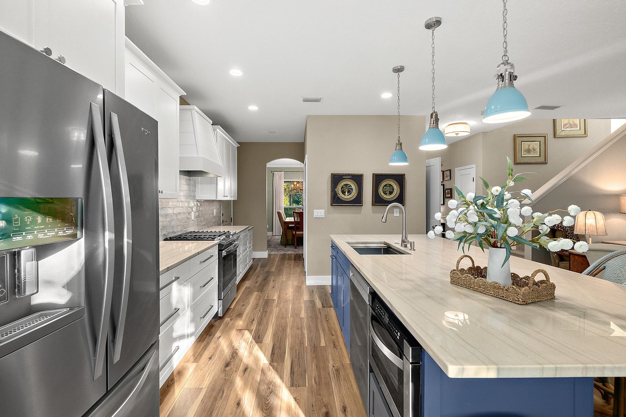 915 Saltwater Circle St. Augustine, FL 32080 - Photo 9 of 60 a kitchen with stainless steel appliances granite countertop a refrigerator a sink dishwasher a oven and a dining table with wooden floor