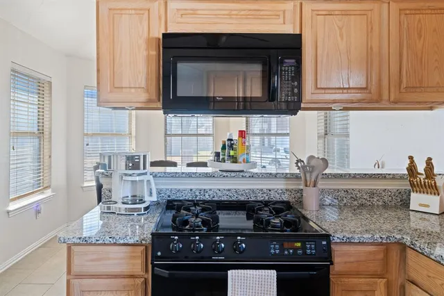 a kitchen with granite countertop a stove and a sink