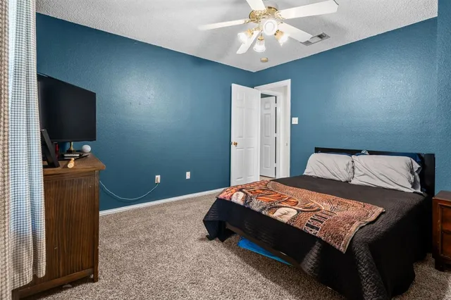 a bedroom with a bed and a flat tv screen on dresser
