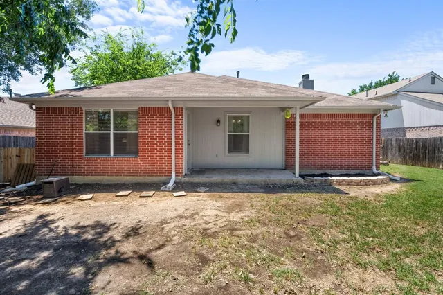 a view of house with yard and a tree