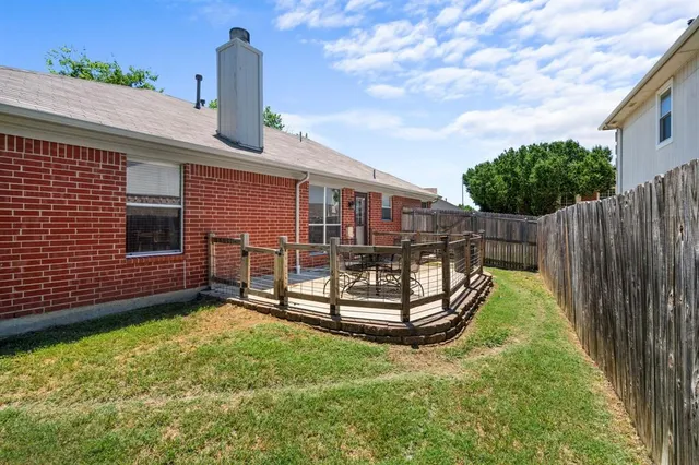 a view of a house with wooden deck and furniture