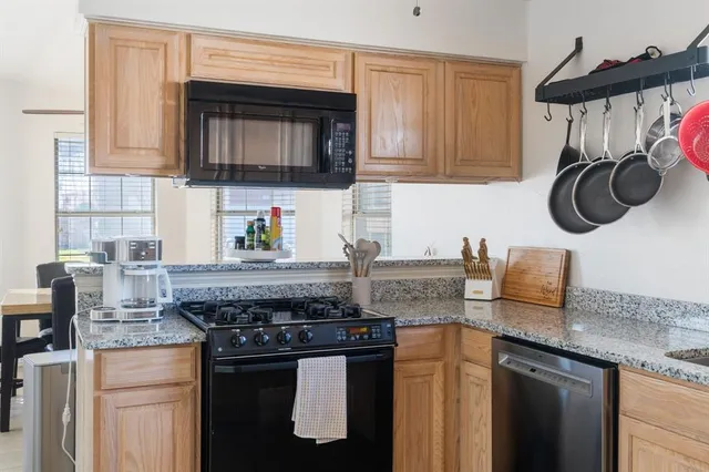 a kitchen with stainless steel appliances granite countertop a stove a microwave and cabinets