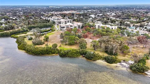an aerial view of residential houses with outdoor space and trees