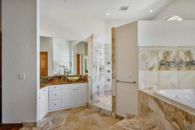 a spacious bathroom with a granite countertop sink mirror and a bath tub
