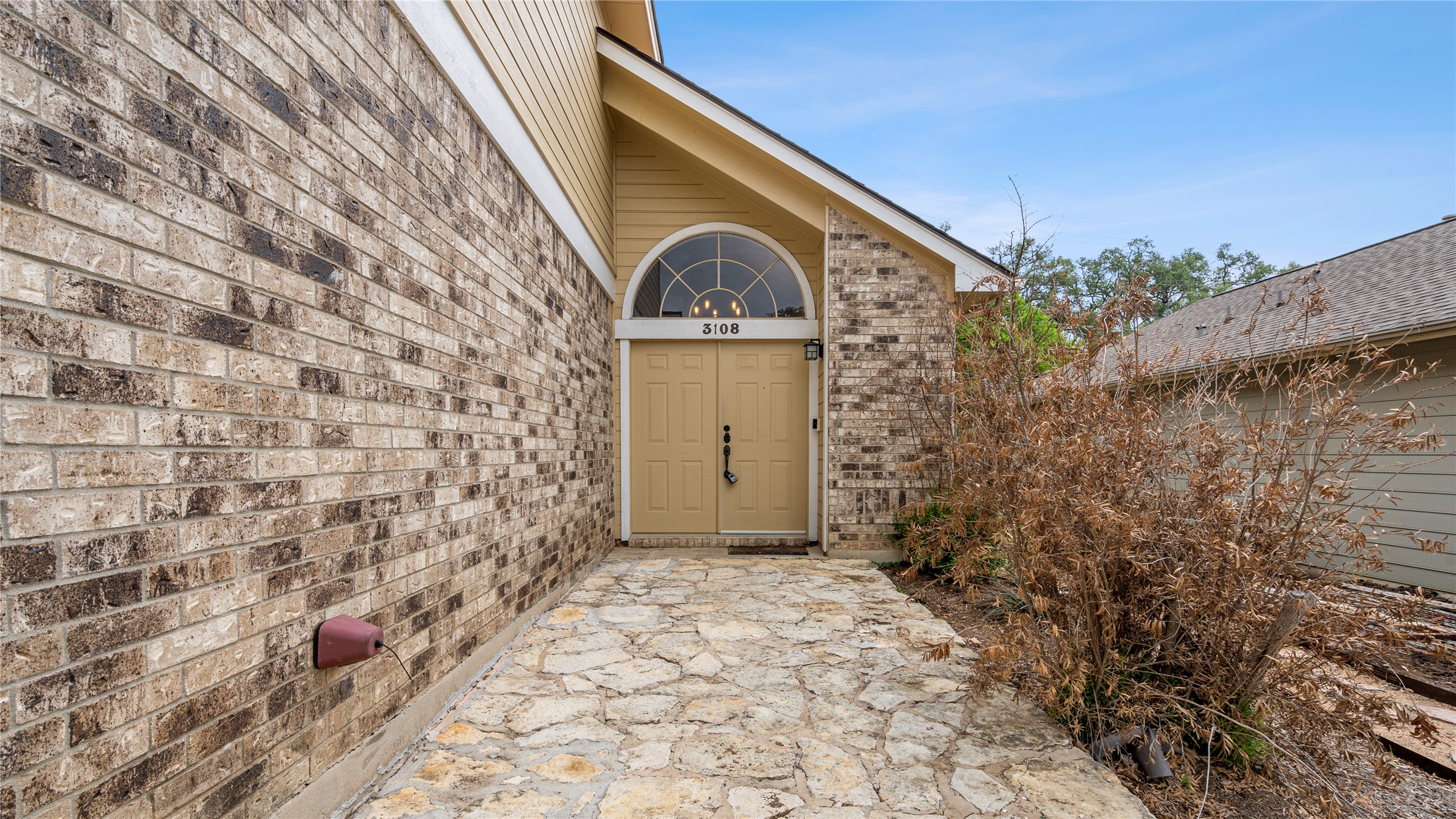 3108 Linnet Drive Austin, TX 78745 - Photo 2 of 24 Property entrance featuring brick siding and a patio area