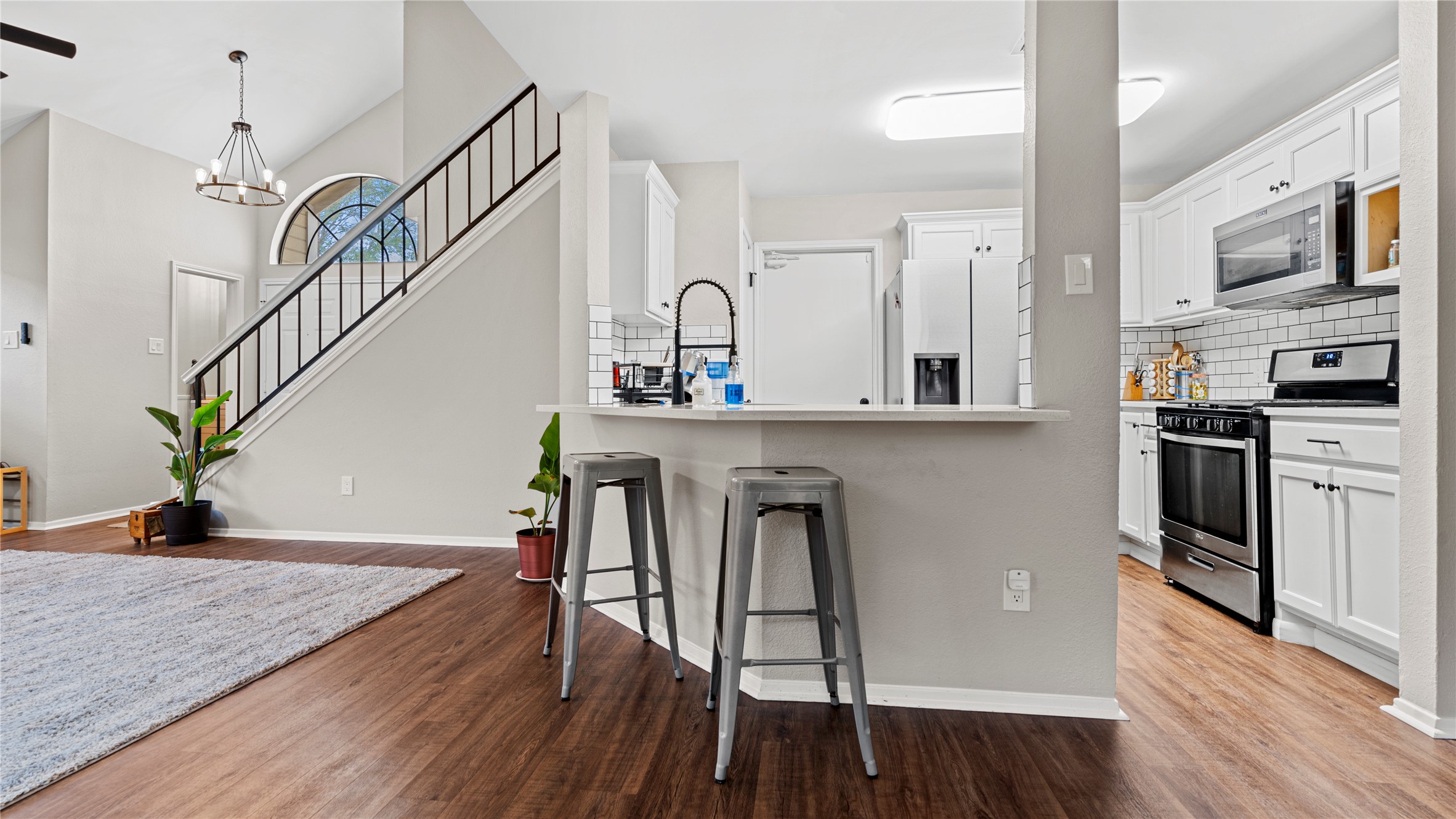 3108 Linnet Drive Austin, TX 78745 - Photo 22 of 24 Kitchen featuring stainless steel appliances, a kitchen breakfast bar, light countertops, a peninsula, and backsplash