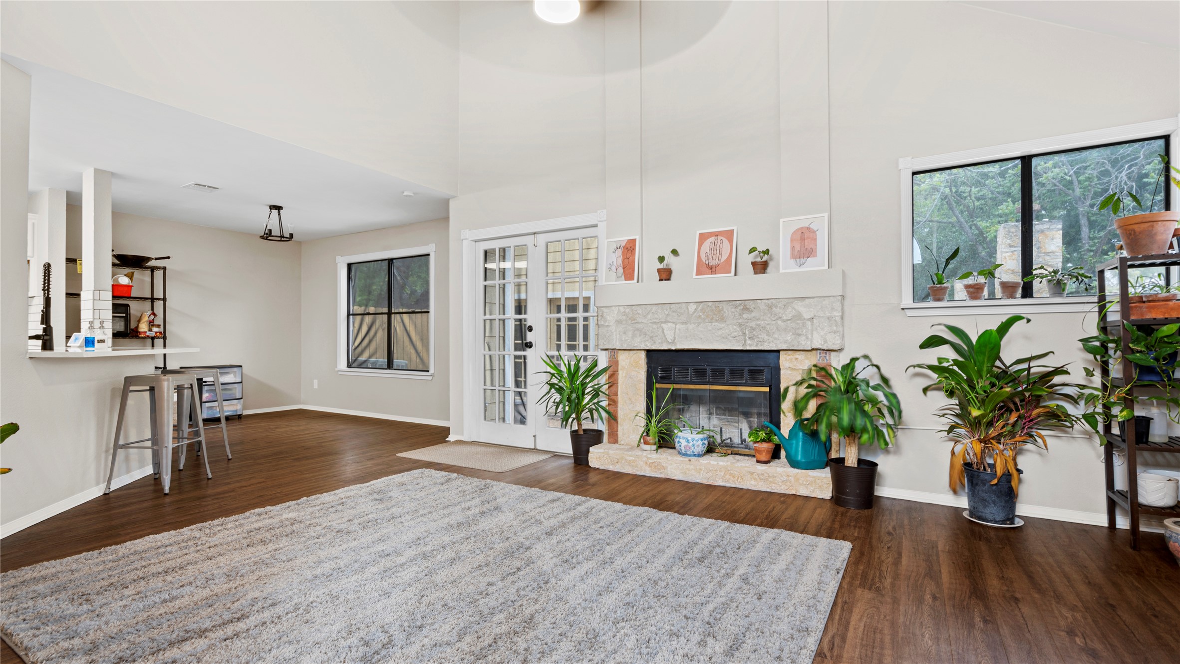 3108 Linnet Drive Austin, TX 78745 - Photo 24 of 24 Living room featuring dark wood-style flooring, a stone fireplace, and a high ceiling