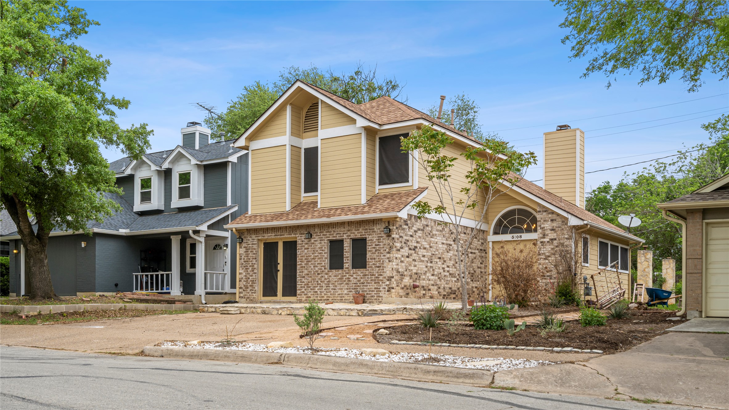 3108 Linnet Drive Austin, TX 78745 - Photo 4 of 24 View of front of property featuring brick siding, a porch, a shingled roof, and a garage