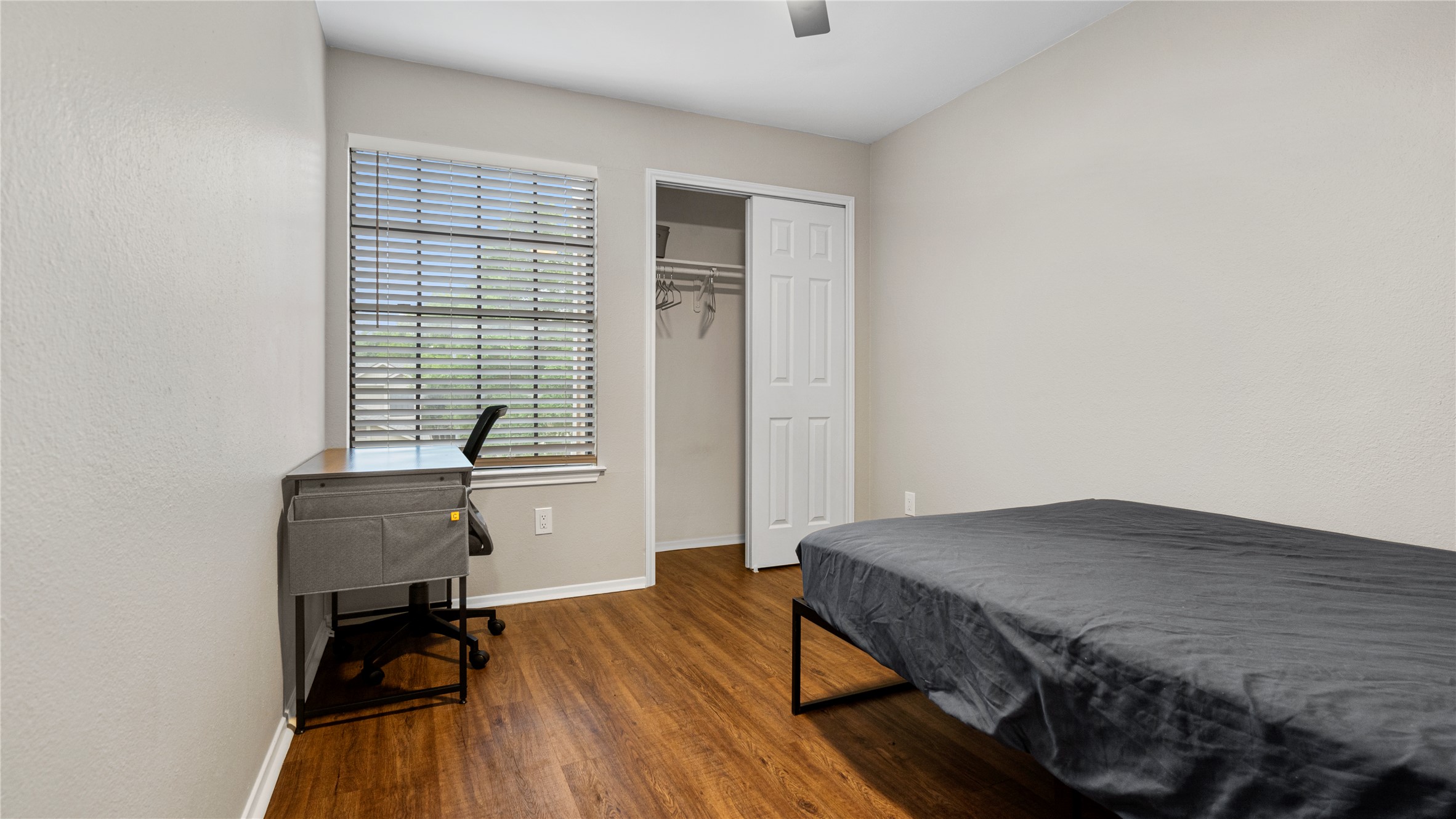 3108 Linnet Drive Austin, TX 78745 - Photo 7 of 24 Bedroom with dark wood-style flooring, a closet, a ceiling fan, and a textured wall