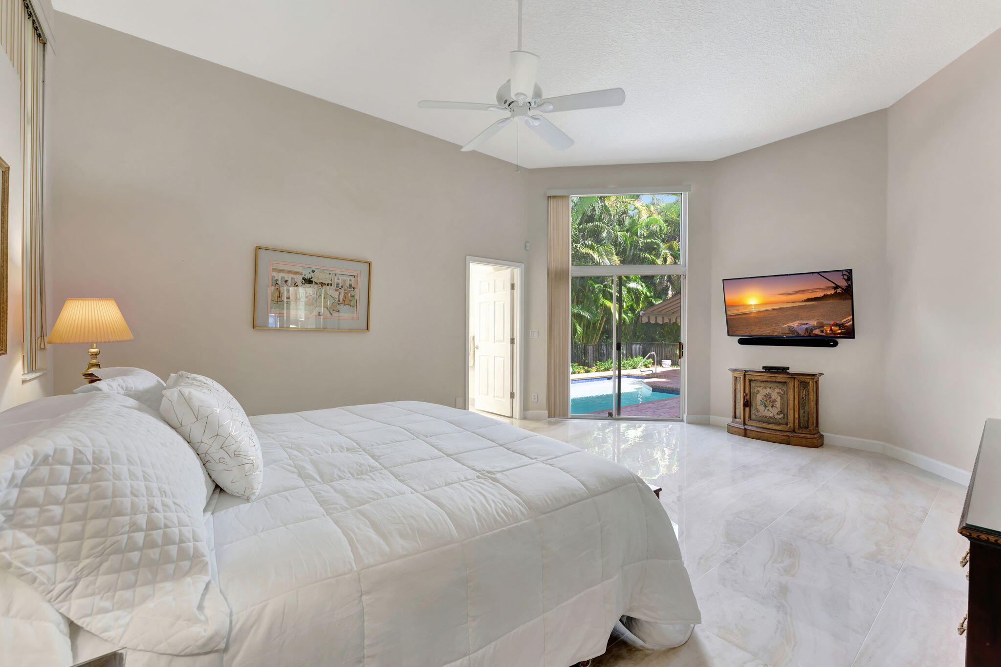 6039 Northwest 31st Terrace Boca Raton, FL 33496 - Photo 43 of 70 a bedroom with a bed and a flat screen tv