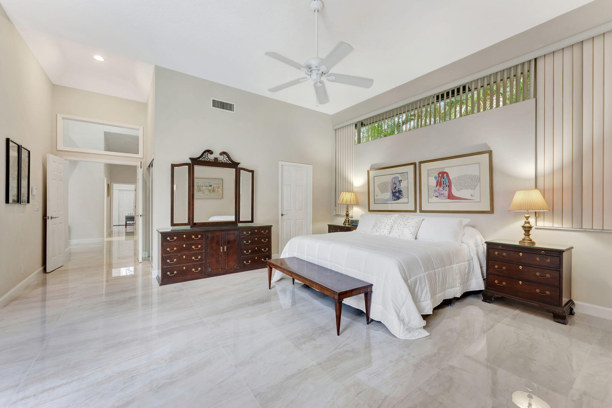 6039 Northwest 31st Terrace Boca Raton, FL 33496 - Photo 44 of 70 a spacious bedroom with a bed and a chandelier