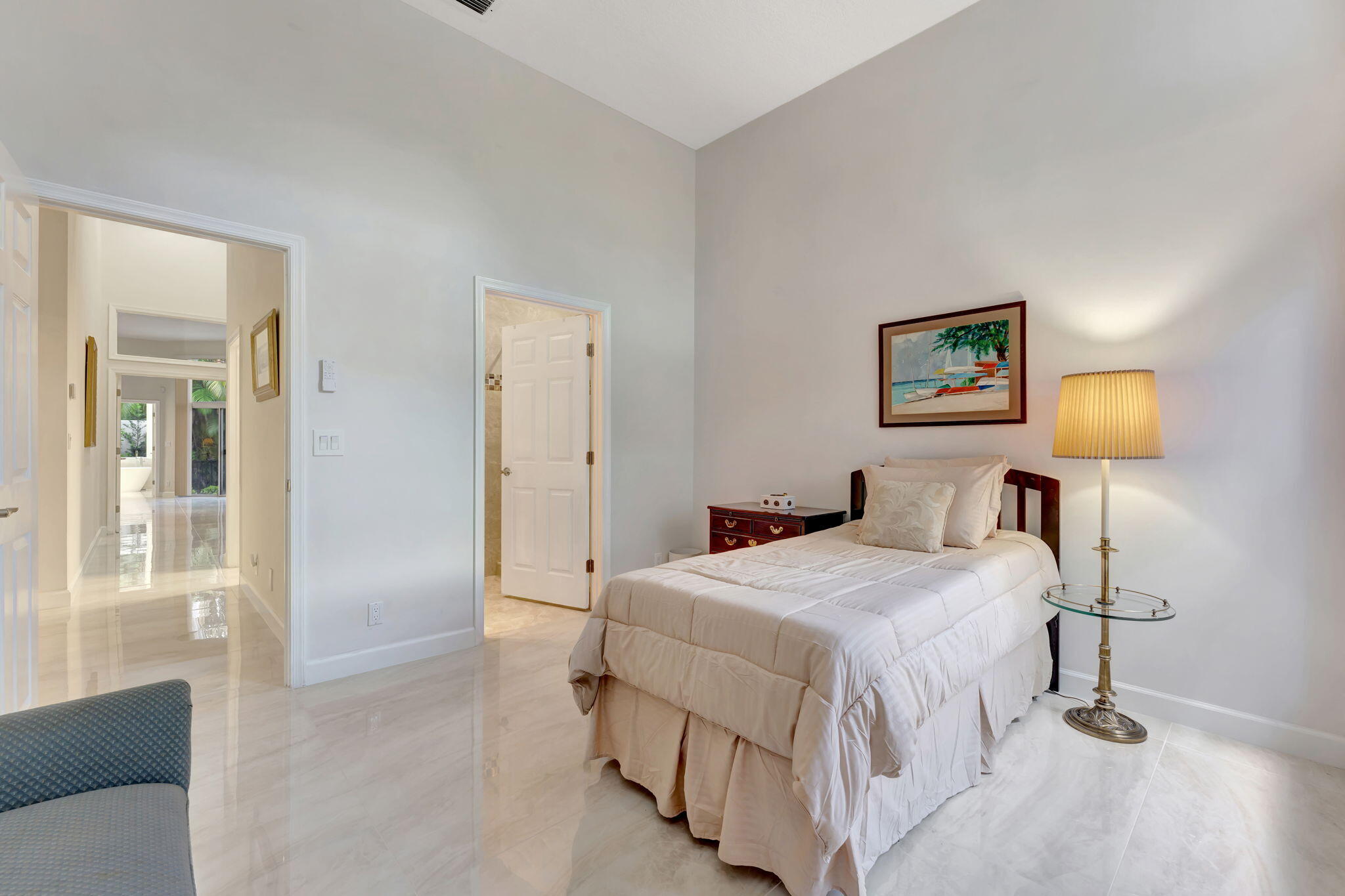 6039 Northwest 31st Terrace Boca Raton, FL 33496 - Photo 52 of 70 a bedroom with a bed and a lamp