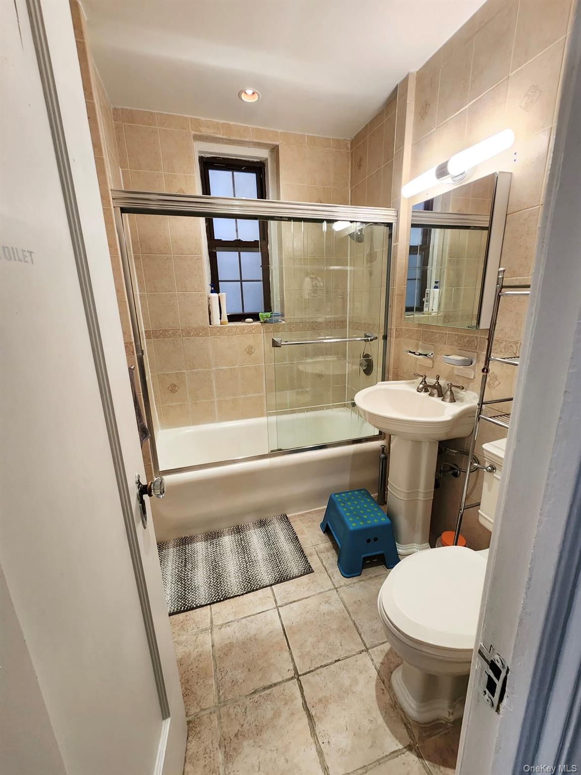 35-21 81st Street, Unit 2A Queens, NY 11372 - Photo 10 of 10 a bathroom with a sink a toilet a mirror and shower