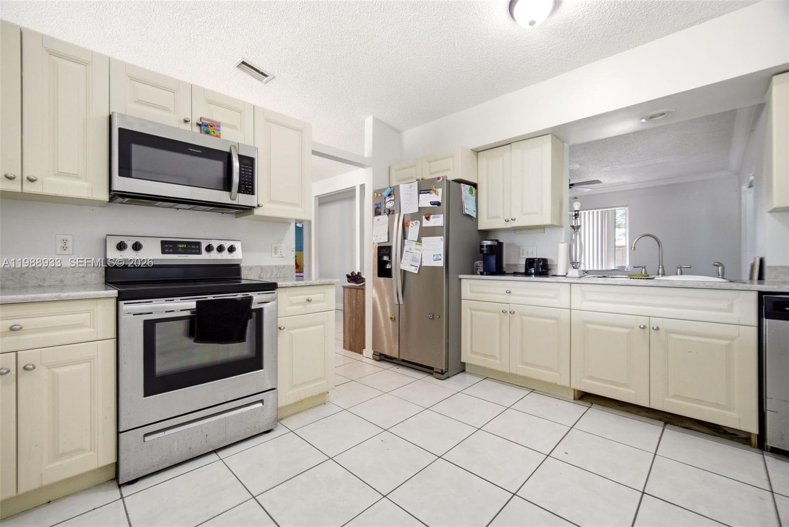 841 Southwest 55th Avenue Margate, FL 33068 - Photo 7 of 26 a kitchen with white cabinets appliances and sink