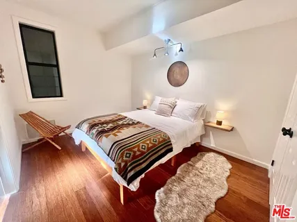 a large bed sitting in a bedroom next to a larger window