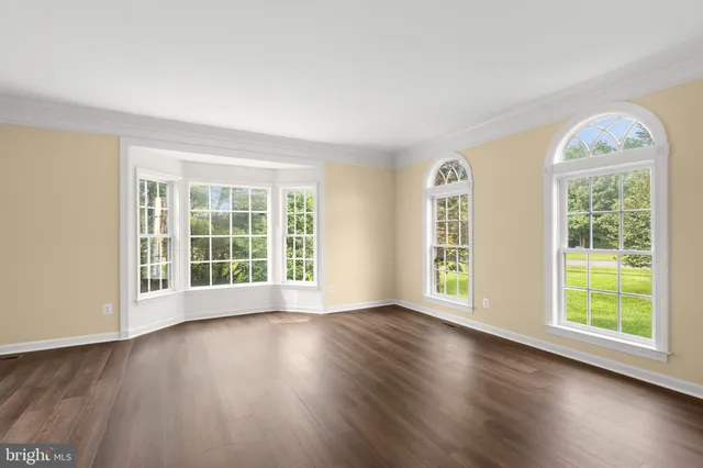 a large kitchen with stainless steel appliances granite countertop a large counter top a sink and a large window