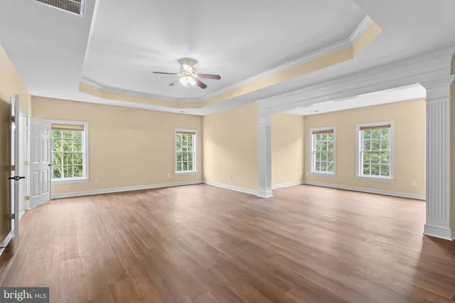 a view of a big room with wooden floor and a chandelier fan