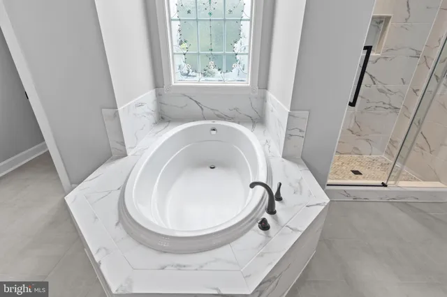 an empty room with wooden floor chandelier fan and windows