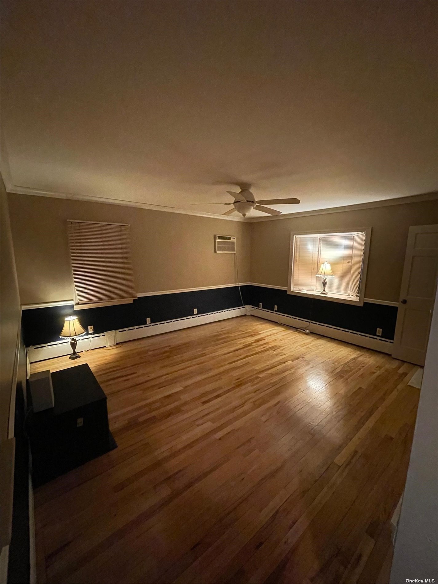 a view of a room with an empty space and wooden floor