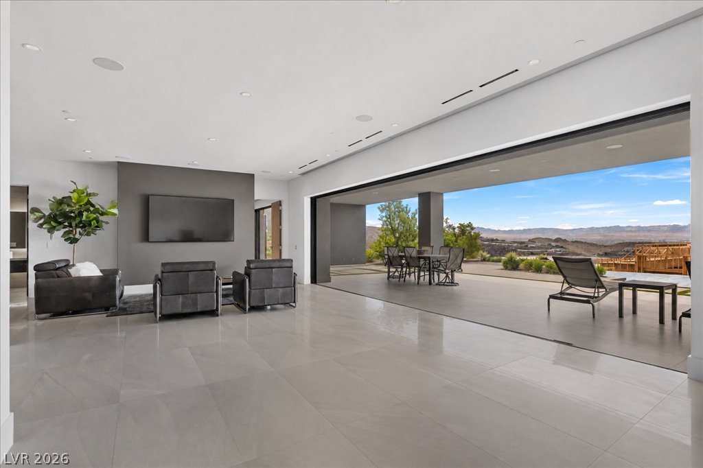 657 Ridgestone Rim Court Henderson, NV 89012 - Photo 54 of 97 Massive sliding glass walls merge the polished tile living area with an expansive outdoor terrace.